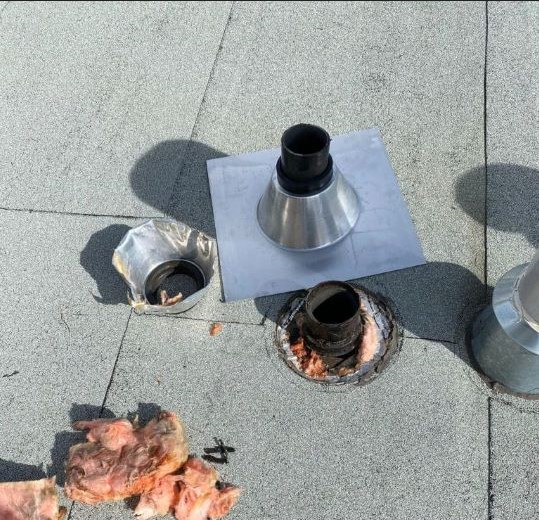Flat roof vent repair with tools and insulation exposed