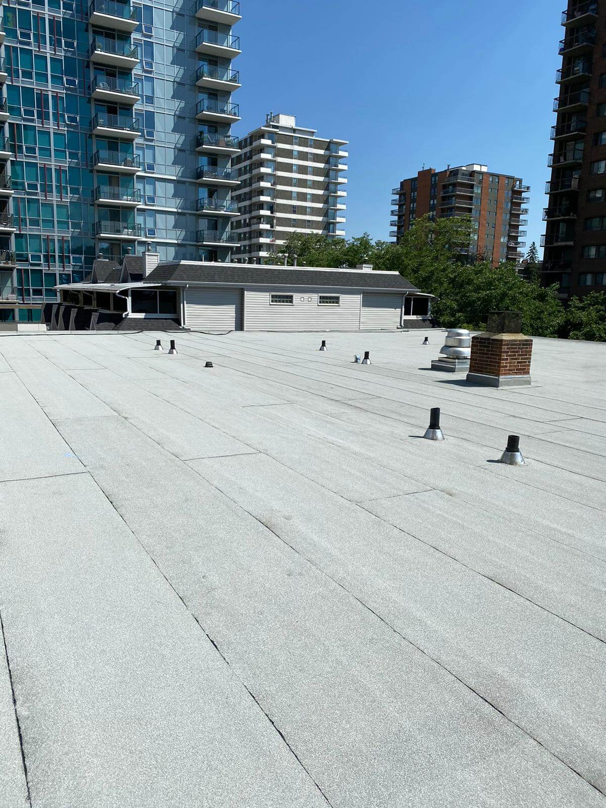 Commercial flat roof inspection and preventative maintenance being performed in Calgary