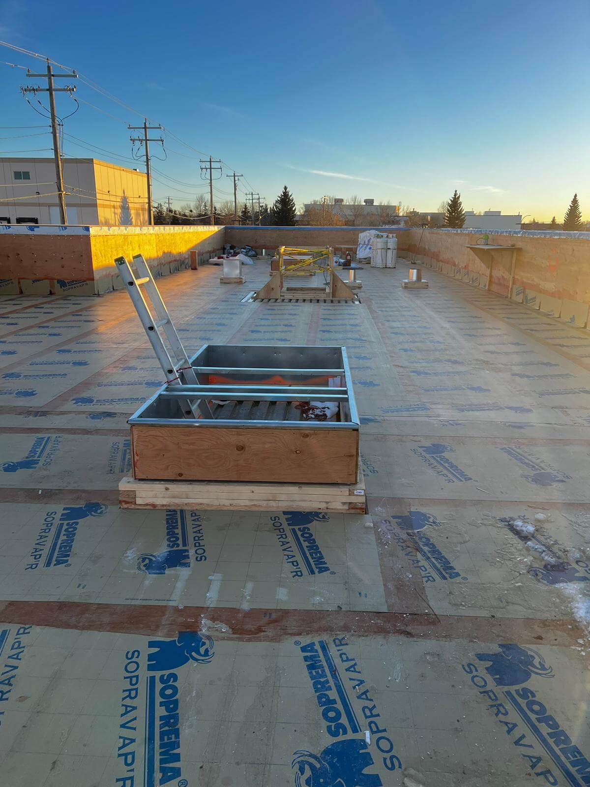 Commercial flat roof replacement with new membrane system being installed on a Calgary business