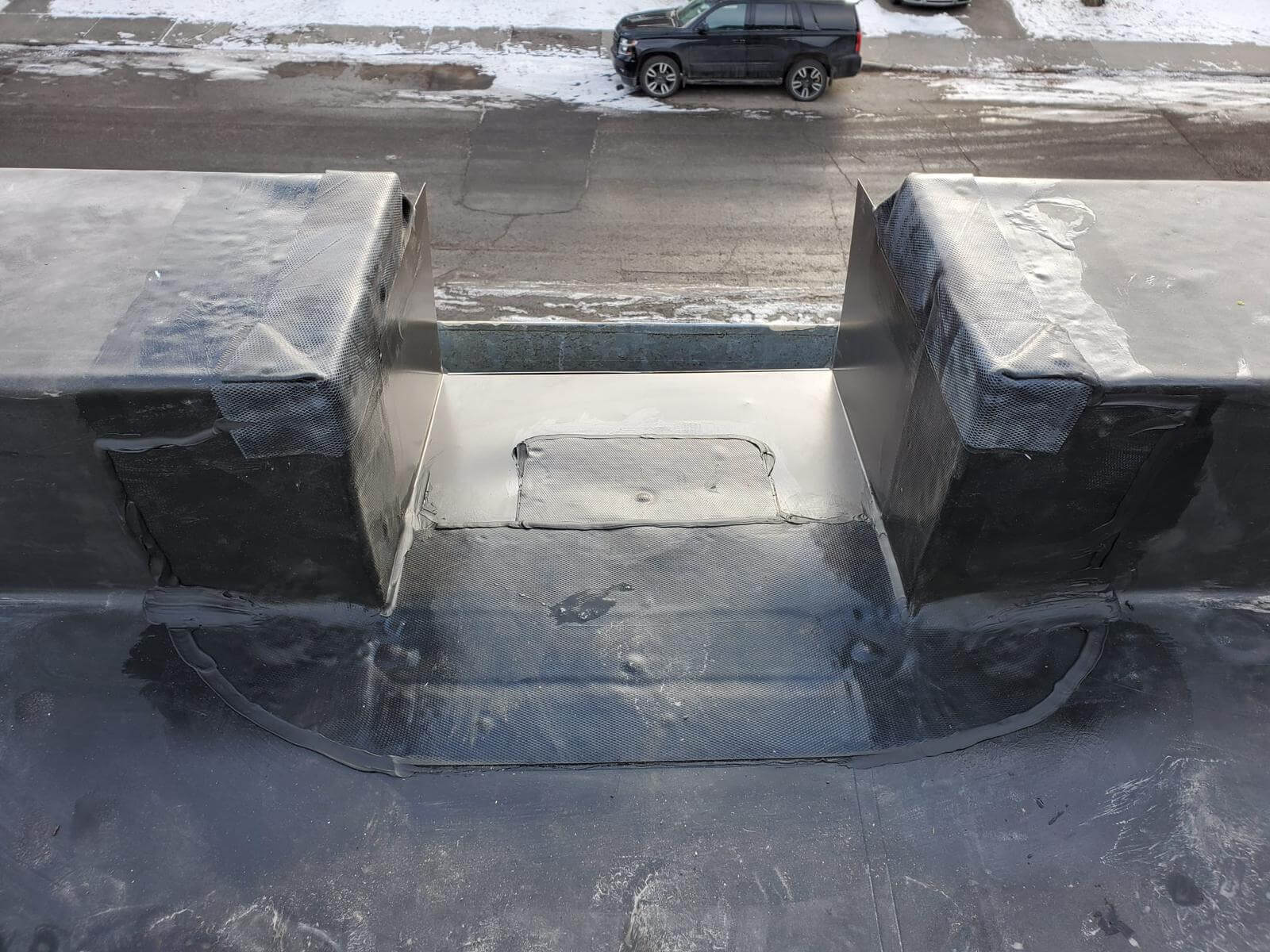 EPDM rubber roof patch and seal repair being applied to fix a damaged area