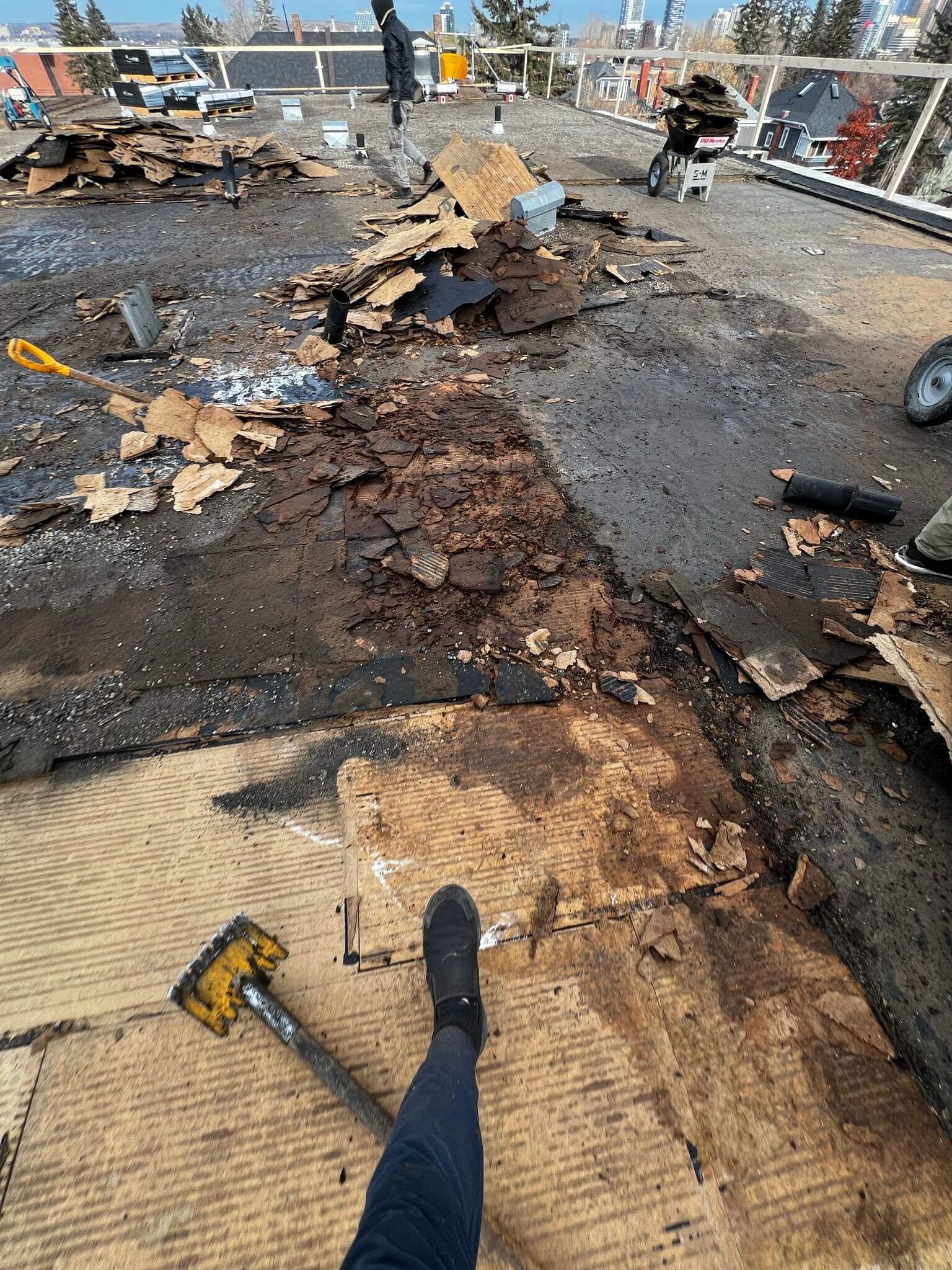Emergency flat roof damage requiring urgent repair with torn membrane and exposed decking