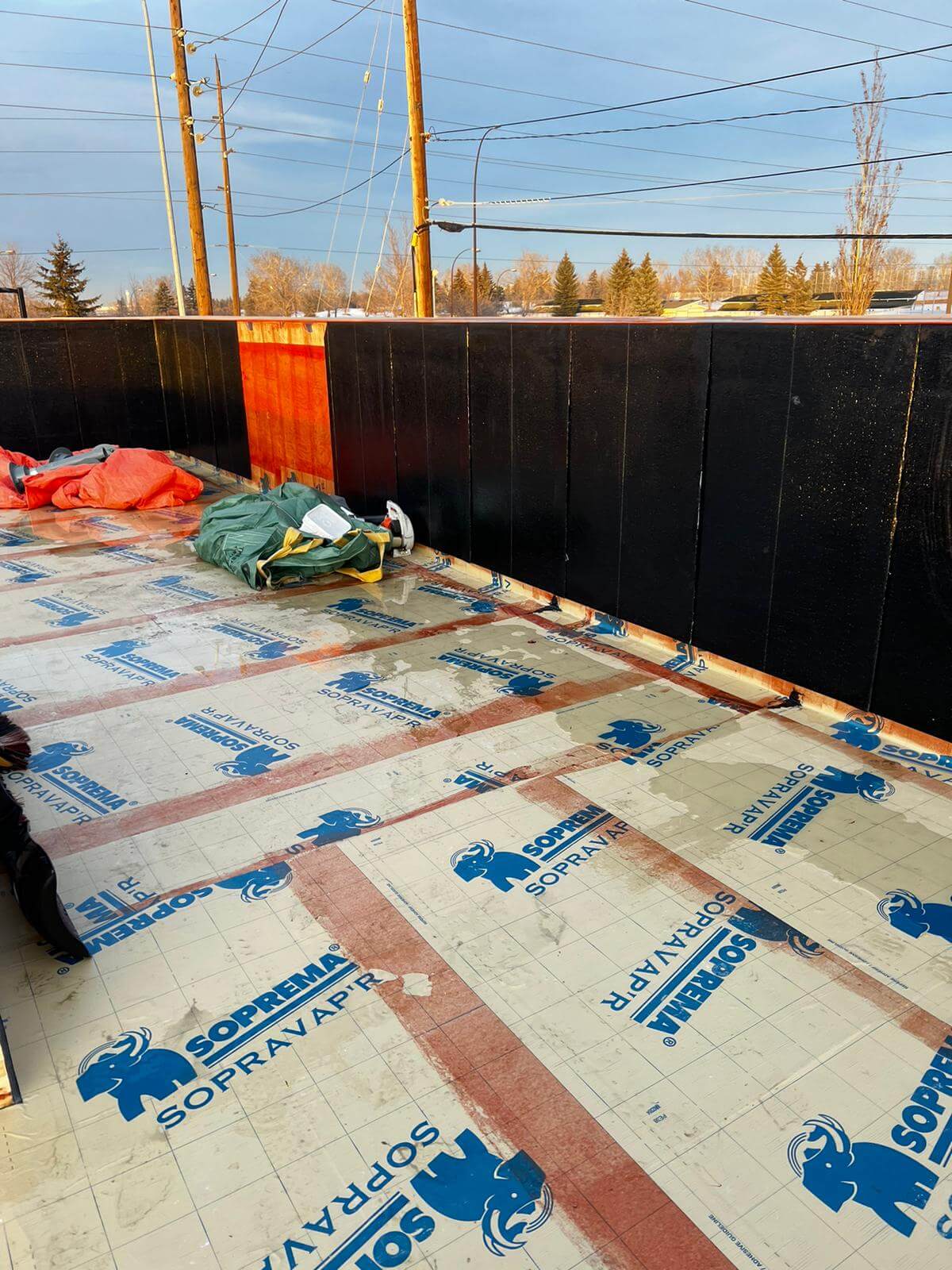 Emergency roof stabilization and temporary protection being applied to a damaged Calgary roof