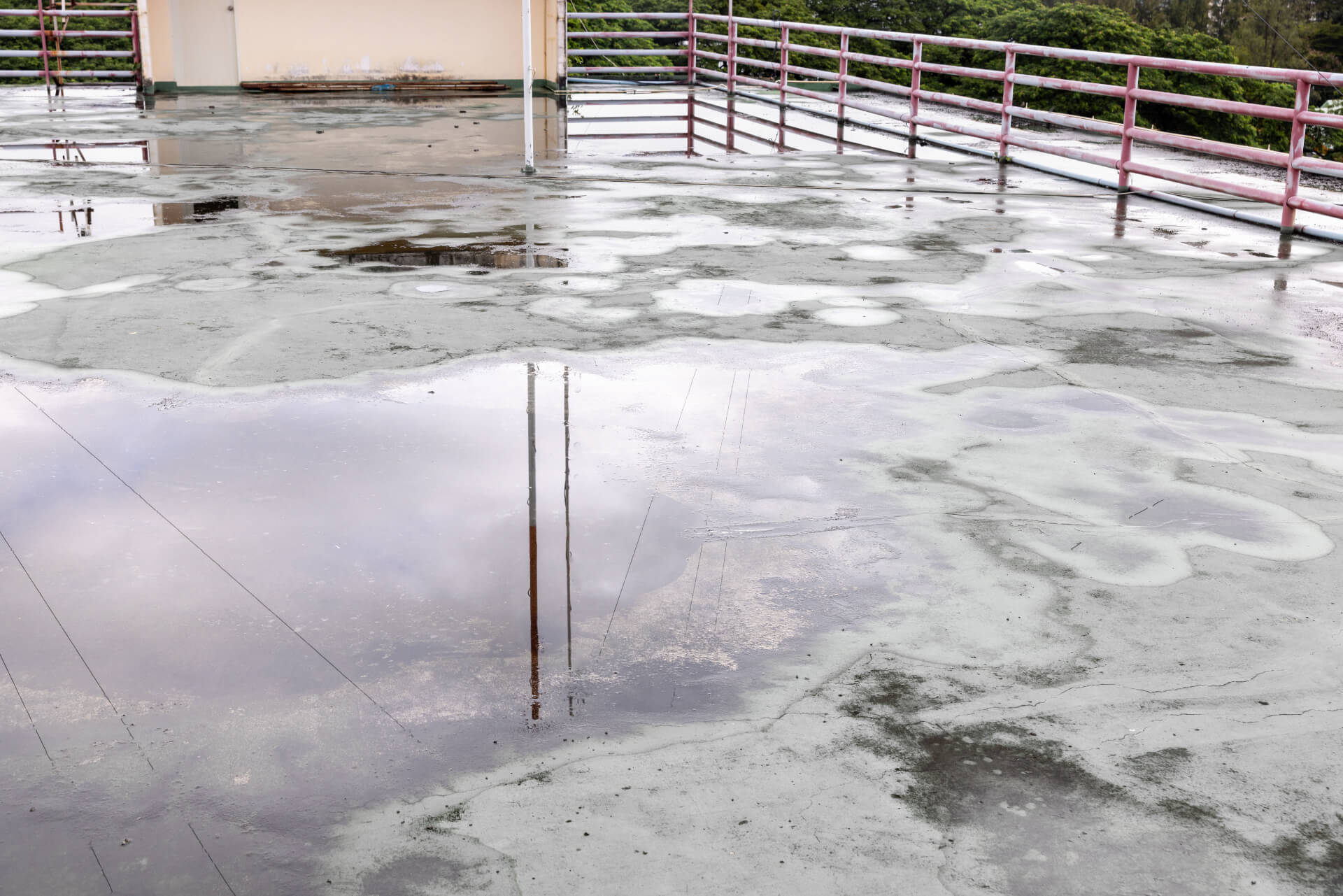Water damage on a flat roof with active leaking requiring emergency repair service