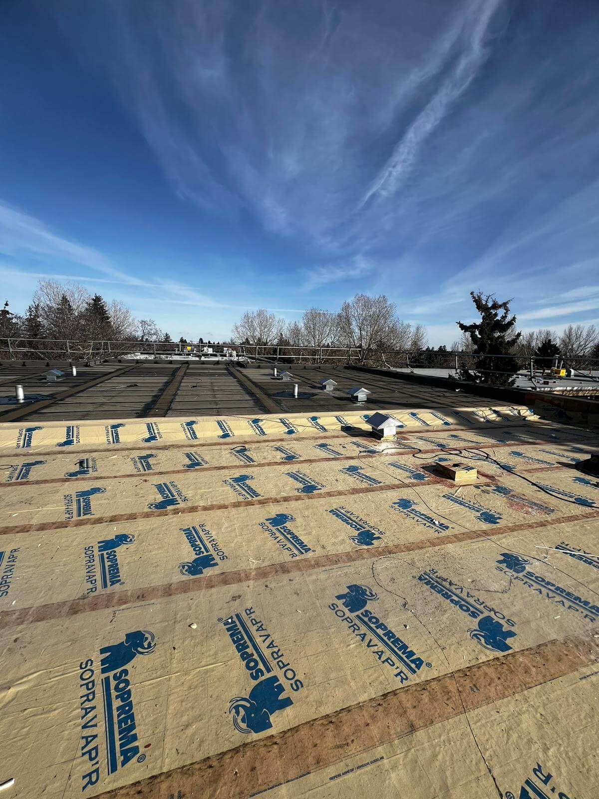 Old flat roof membrane being torn off and removed during a full roof replacement in Calgary