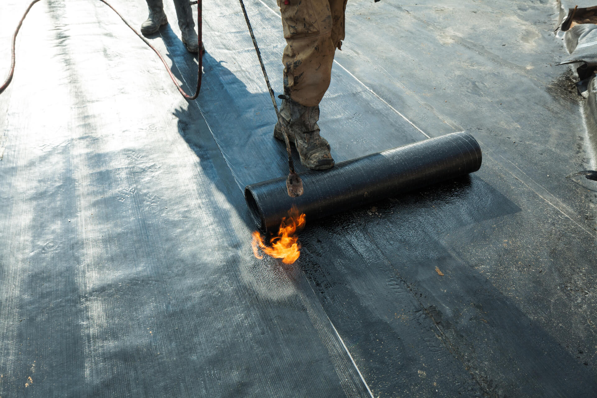 SBS modified bitumen roofing membrane being torch-applied on a flat roof