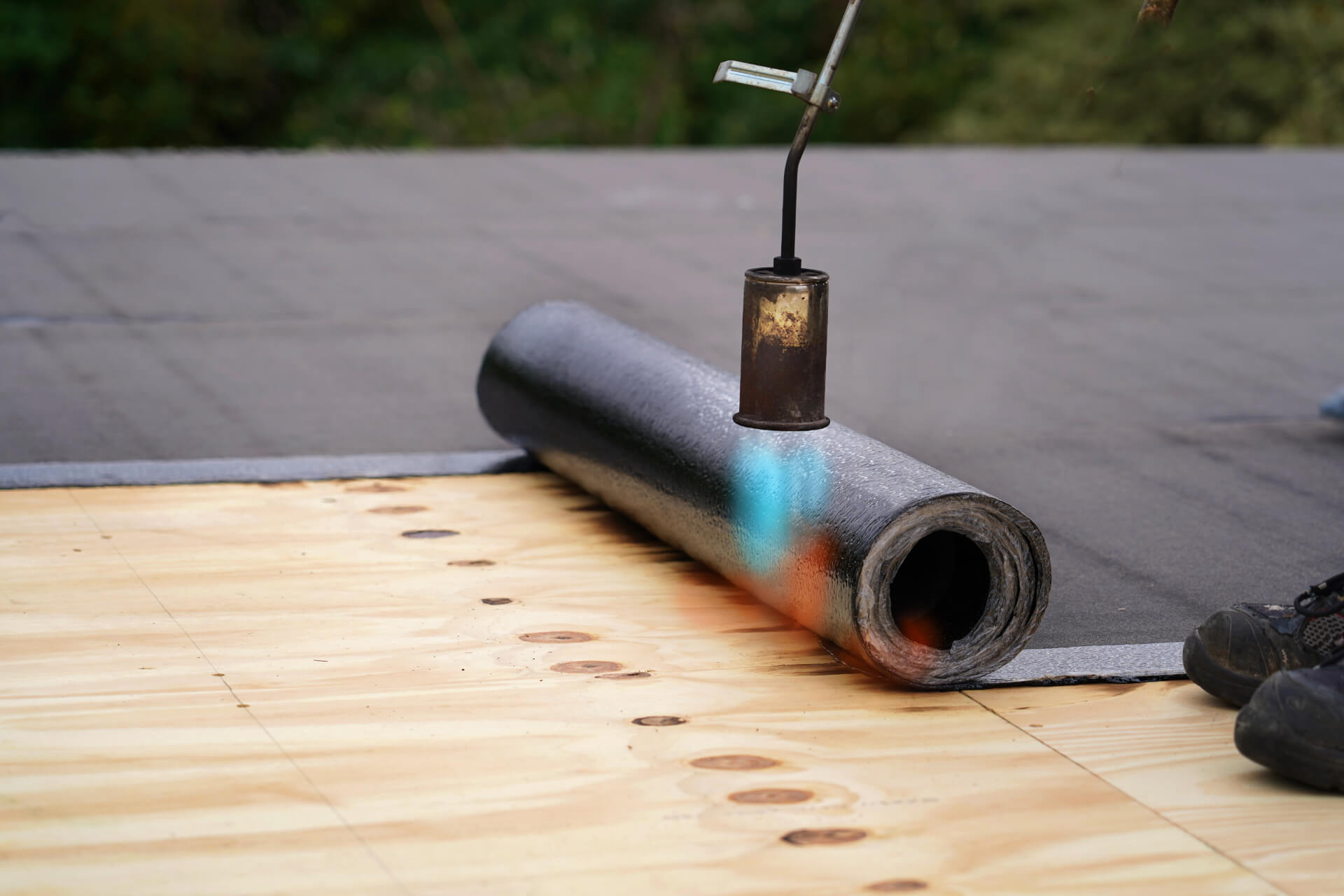 SBS modified bitumen torch-on roof installation with propane torch applying membrane in Calgary